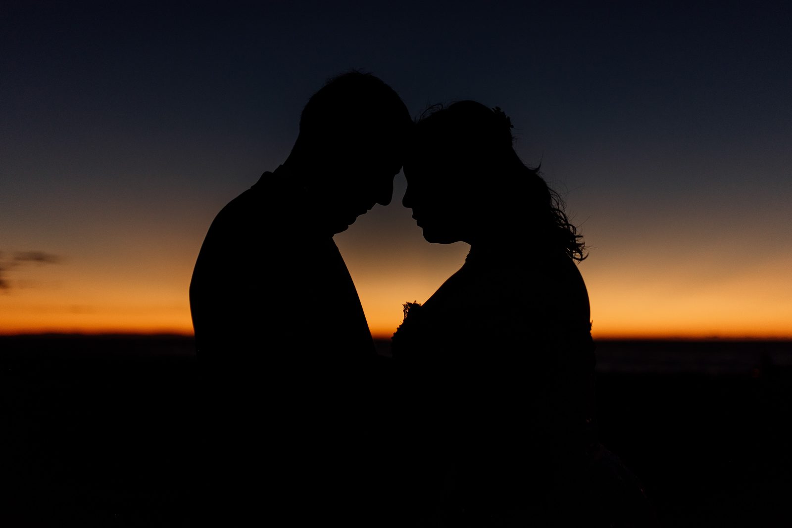 Los novios recortados contra el atardecer