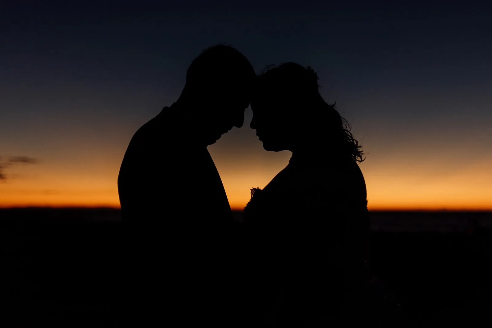 Los novios recortados contra el atardecer
