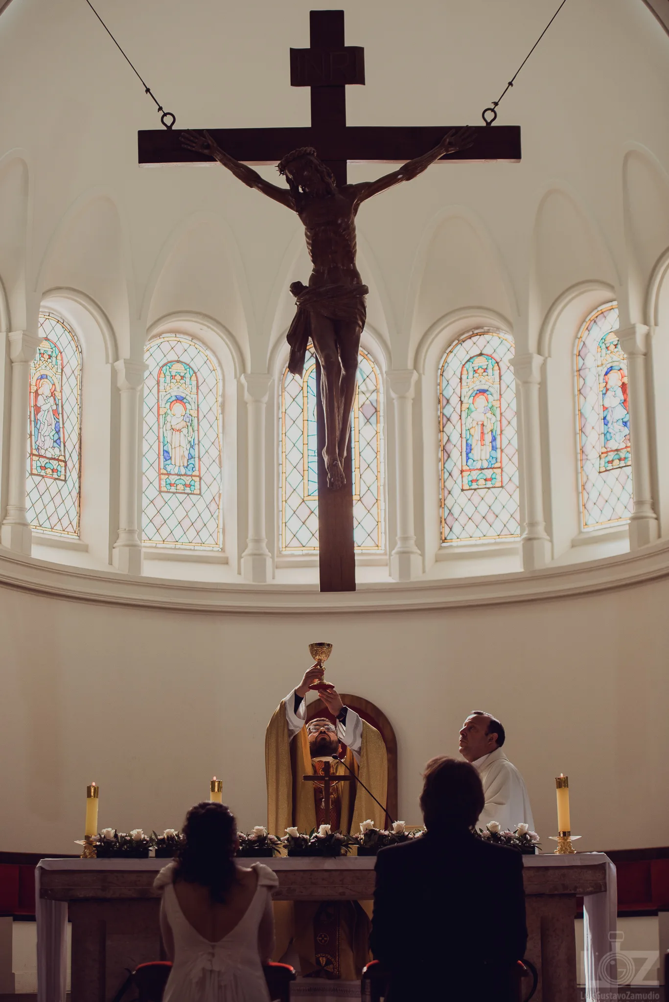 Ceremonia religiosa de matrimonio frente al altar de una iglesia con vitrales en Concepción