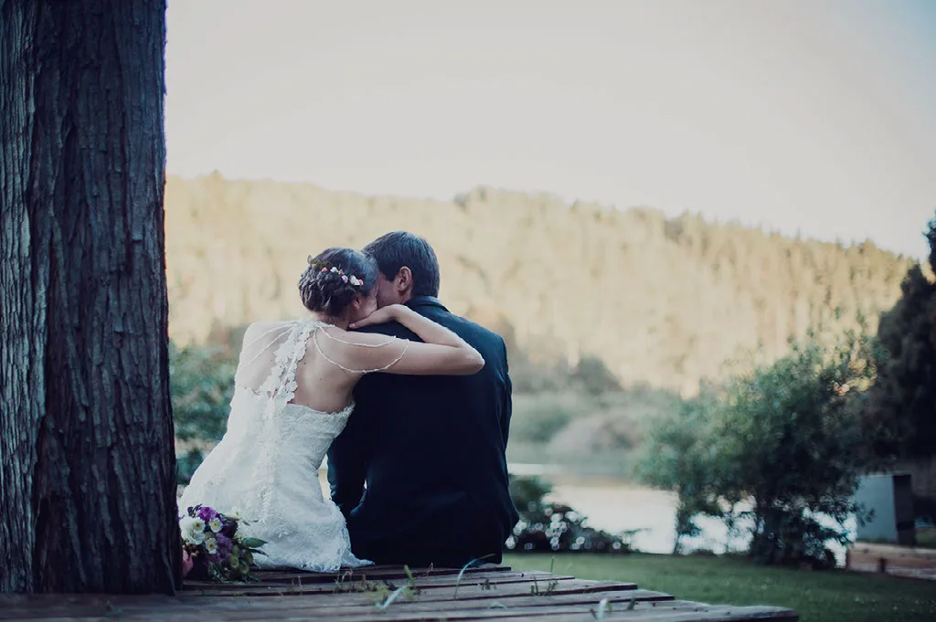 Novios abrazados frente al río en su sesión de fotos de matrimonio cerca de Concepción
