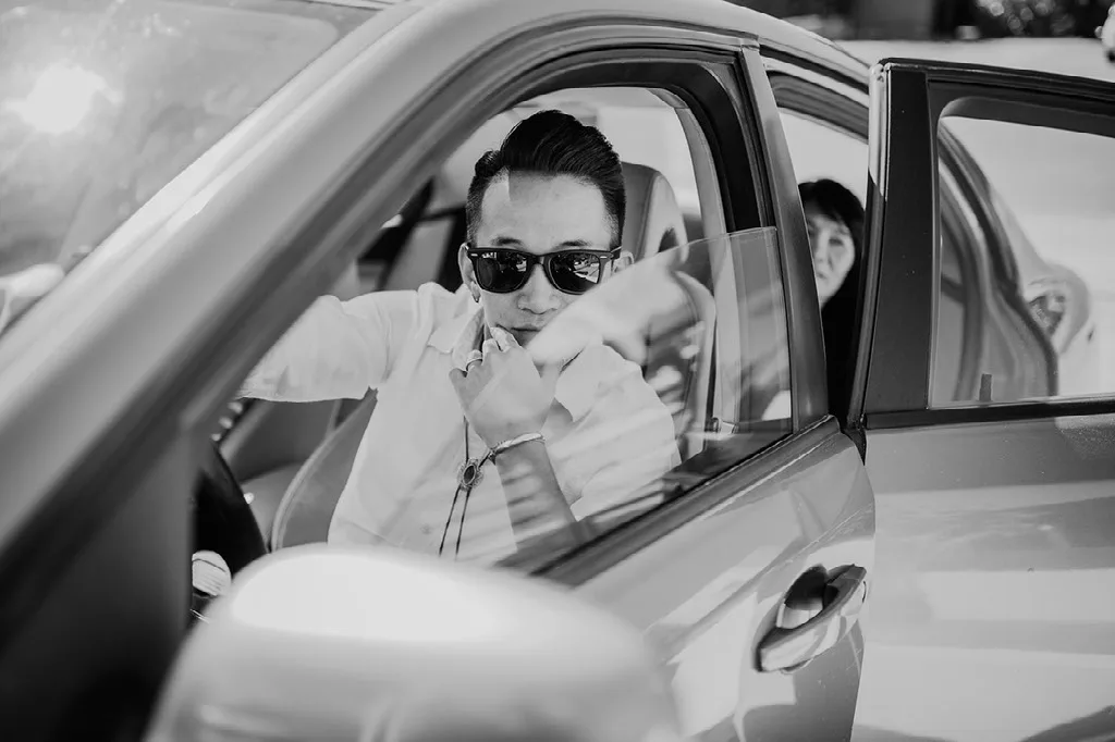 Novio poniéndose los lentes de sol dentro del auto, fotografía documental en blanco y negro
