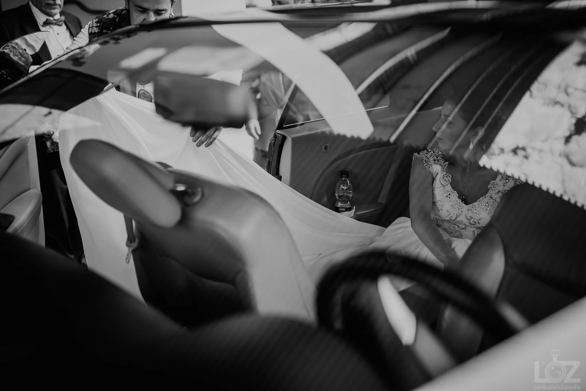 Velo de la novia colgado en el interior del auto de novios, detalle en blanco y negro
