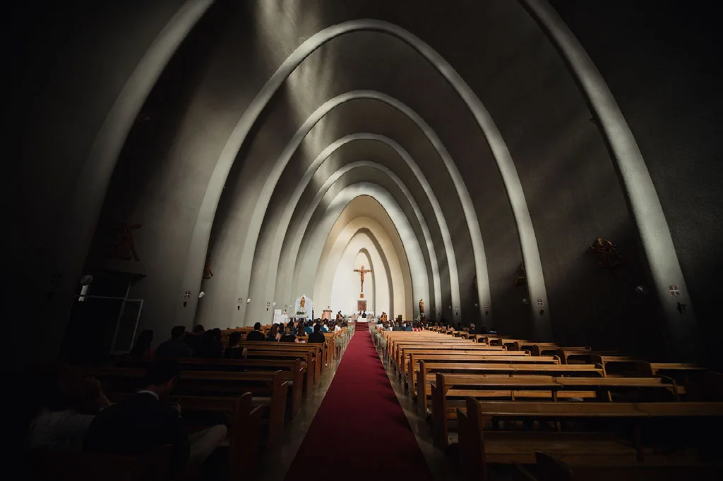 Nave central de la iglesia con sus arcos iluminados durante la ceremonia de matrimonio