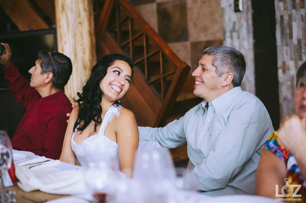 Novia riendo junto a su familia en la cena de su matrimonio