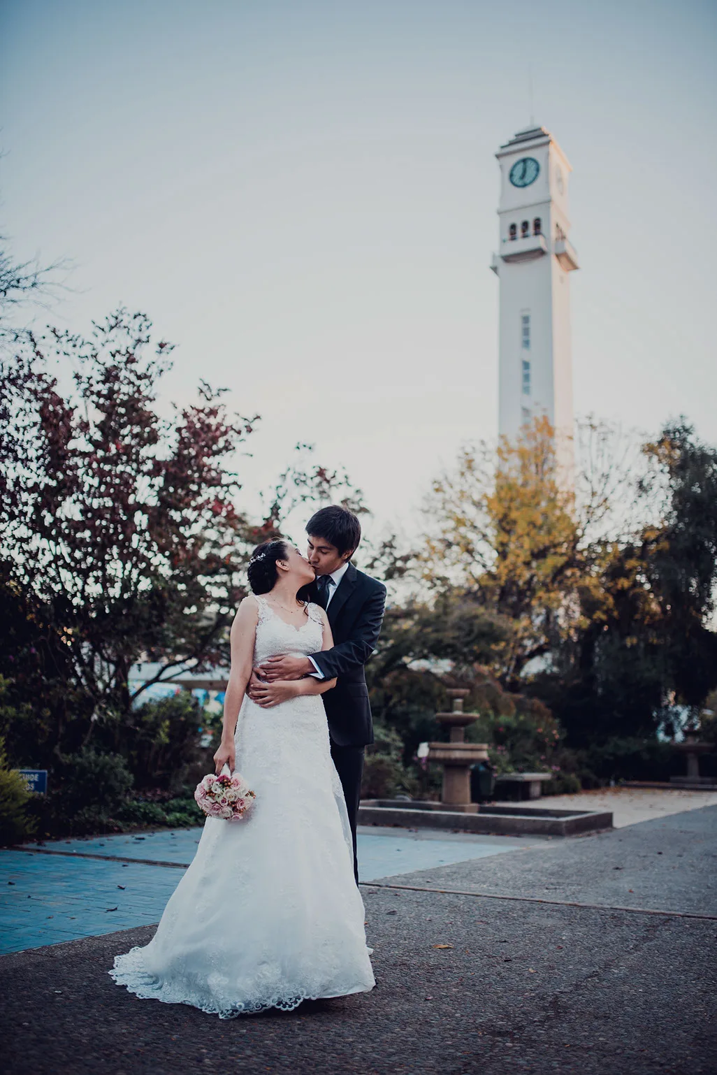 Novios abrazados frente al Campanil de la Universidad de Concepción