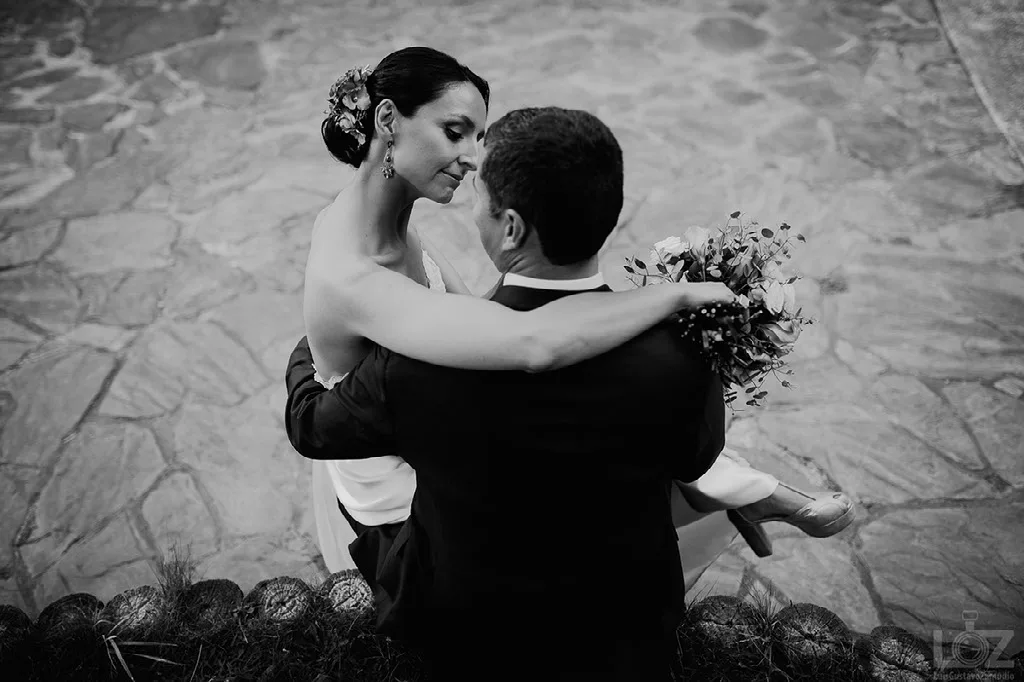 Novios bailando en el patio de piedra, fotografía en blanco y negro