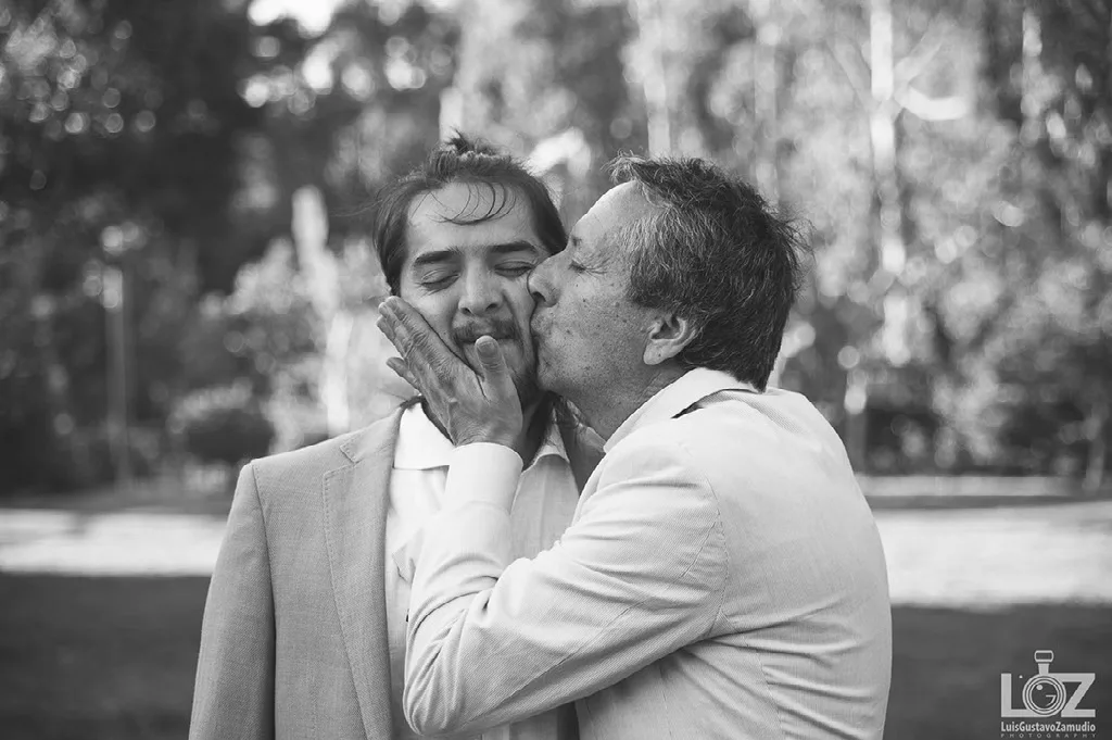 El padre besa al novio antes de la ceremonia, momento documental en blanco y negro