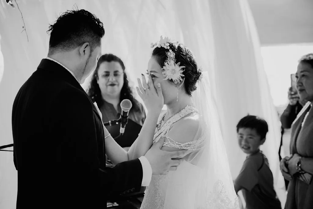 Novia emocionada durante los discursos de la ceremonia, blanco y negro