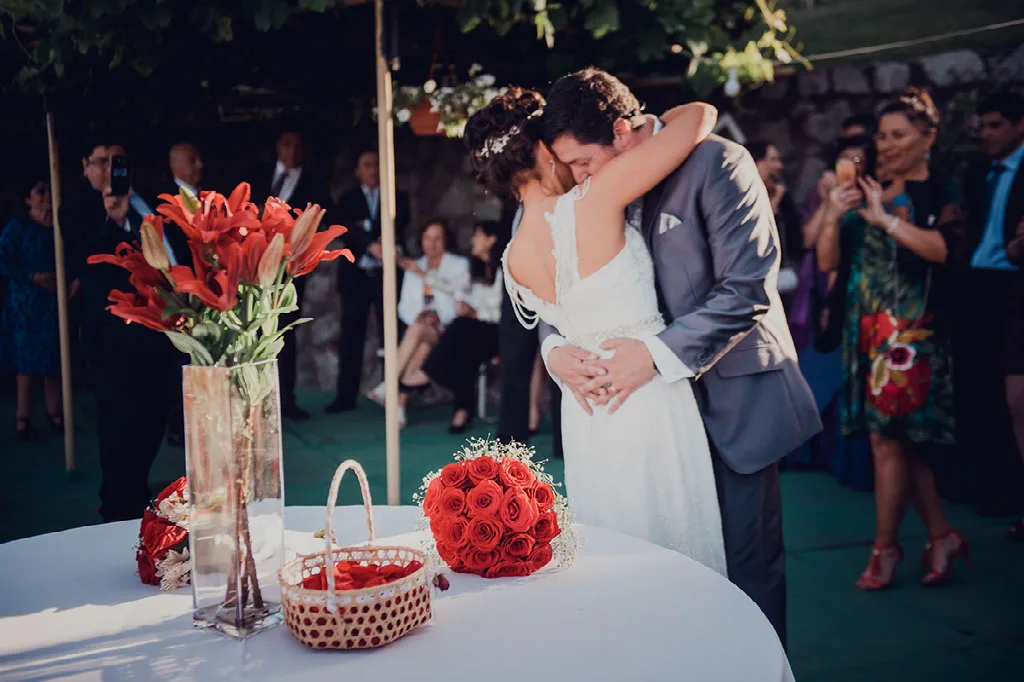Abrazo de los novios junto a la mesa de la torta entre los aplausos de los invitados