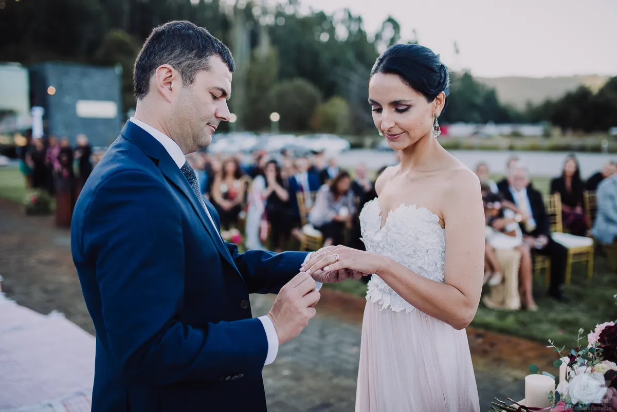El novio pone el anillo a la novia en su matrimonio civil al aire libre