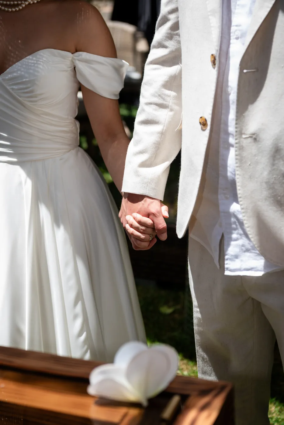 Los novios de la mano junto a la mesa de su civil