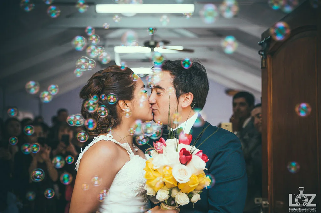 Beso de los novios entre burbujas a la salida de su ceremonia